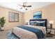 Serene bedroom features a ceiling fan, a picture window, and soft blue accents for a calming atmosphere at 1623 E Leaf Rd, San Tan Valley, AZ 85140