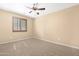 Comfortable bedroom with soft carpeting, a ceiling fan, and wooden-shuttered window offering privacy and style at 1623 E Leaf Rd, San Tan Valley, AZ 85140