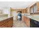 Bright kitchen featuring light wood cabinets, granite countertops, black appliances, and tile floors at 1623 E Leaf Rd, San Tan Valley, AZ 85140