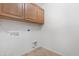 Bright laundry room with utility hookups and classic cabinets, creating a functional and tidy space at 1623 E Leaf Rd, San Tan Valley, AZ 85140