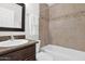 Clean bathroom featuring a shower-tub combination, tiled walls, and a vanity sink at 16421 N 65Th Pl, Scottsdale, AZ 85254