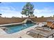 Relaxing backyard pool area with a rock waterfall feature, lounge chairs, and mature landscaping at 17244 N 29Th Ave, Phoenix, AZ 85053