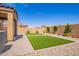 Backyard features faux grass patches, mature landscaping, and a covered patio at 1762 E Elegante Dr, Casa Grande, AZ 85122
