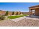 Backyard features faux grass patches, mature landscaping, and a covered patio at 1762 E Elegante Dr, Casa Grande, AZ 85122
