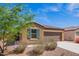 Well maintained single-story home with low maintenance landscaping, blue sky and flowering bushes at 1762 E Elegante Dr, Casa Grande, AZ 85122