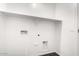 All-white laundry room with shelving and hookups for washer and dryer at 1762 E Elegante Dr, Casa Grande, AZ 85122