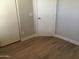 Neutral bedroom corner with wood-look flooring, closet and a door, perfect for customization at 1827 E Carla Vista Dr, Gilbert, AZ 85295