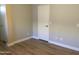 Neutral bedroom with wood-look flooring and white door at 1827 E Carla Vista Dr, Gilbert, AZ 85295