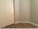 Compact bedroom featuring wood-look floors, neutral walls, and a closet for efficient space utilization at 1827 E Carla Vista Dr, Gilbert, AZ 85295
