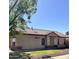 Single-story home with neutral stucco exterior, tile roof, desert landscaping, and manicured lawn at 1827 E Carla Vista Dr, Gilbert, AZ 85295