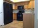 Functional kitchen with wood cabinets, black appliances, and updated flooring for easy maintenance at 1827 E Carla Vista Dr, Gilbert, AZ 85295