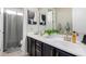 Bright bathroom with dual sinks, dark cabinets, brushed gold hardware, and decorative wall art at 20366 E Via De Colina --, Queen Creek, AZ 85142