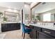 Bright bathroom with dual sinks, black cabinets, brushed gold hardware, and a wooden framed mirror at 20366 E Via De Colina --, Queen Creek, AZ 85142