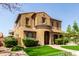 Beautiful two-story home featuring a covered carport, arched entry, and lush greenery at 20366 E Via De Colina --, Queen Creek, AZ 85142