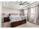 Main bedroom with a tray ceiling, a ceiling fan, and large windows with elegant curtains at 20366 E Via De Colina --, Queen Creek, AZ 85142