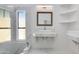 Bright bathroom featuring marble walls and floors, with a modern vanity, sink, mirror, and window at 2132 E Northview Ave, Phoenix, AZ 85020
