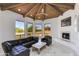 Bright living room with wood vaulted ceiling, fireplace, black leather seating, and marble floors at 2132 E Northview Ave, Phoenix, AZ 85020