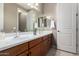 Bathroom featuring double sinks, white countertops, and warm wood cabinetry at 2507 E Eleana Ln, Gilbert, AZ 85298