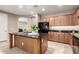 Spacious kitchen with a central island, black appliances and tan cabinets at 2507 E Eleana Ln, Gilbert, AZ 85298