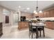 Bright kitchen featuring tan cabinets, a center island with granite countertops and black appliances at 2507 E Eleana Ln, Gilbert, AZ 85298
