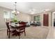 Open-concept living and dining area with neutral tones, comfortable seating, and stylish chandelier at 2507 E Eleana Ln, Gilbert, AZ 85298