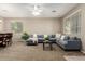 Spacious living room features plush carpet, large sectional sofa, and ample natural light from the windows at 2507 E Eleana Ln, Gilbert, AZ 85298