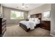 Calming main bedroom with a ceiling fan, two dressers, two night stands and a window at 2507 E Eleana Ln, Gilbert, AZ 85298
