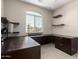 Well-lit office space with a large desk, floating shelves, and natural light at 2507 E Eleana Ln, Gilbert, AZ 85298
