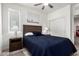 Comfortable bedroom with a wood frame bed, ceiling fan, bedside tables and southwest themed artwork at 300 N Gila Springs Blvd # 181, Chandler, AZ 85226