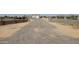 Gravel driveway leading to a gated property with metal buildings, enclosed by concrete fencing with wrought iron toppers at 30940 N Varnum Rd, San Tan Valley, AZ 85143