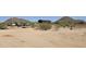 Expansive desert property with vehicle and metal building in the background at 30940 N Varnum Rd, San Tan Valley, AZ 85143