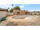 View of empty backyard pool surrounded by concrete, a fence, desert landscaping, and exterior of the home at 3138 W Danbury Dr, Phoenix, AZ 85053