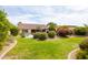 Lush backyard with manicured lawn, desert landscaping, and mature trees at 4020 W Menadota Dr, Glendale, AZ 85308