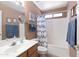 Bright bathroom with ample counter space, and well-lit vanity, and shower with a curtain at 4020 W Menadota Dr, Glendale, AZ 85308