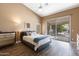 Cozy main bedroom featuring a ceiling fan and a sliding glass door that leads to a backyard patio at 4020 W Menadota Dr, Glendale, AZ 85308