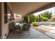 Inviting covered patio features an outdoor dining area and a view of the pool and landscaped yard at 4020 W Menadota Dr, Glendale, AZ 85308