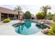 Swimming pool surrounded by desert landscaping and palm trees at 4020 W Menadota Dr, Glendale, AZ 85308