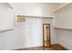 A generous walk-in closet provides ample storage space with wood shelving, rods, and a mirror at 4020 W Menadota Dr, Glendale, AZ 85308