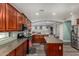 Open kitchen features dark cabinets, kitchen island, gas range, stainless steel appliances, and wood-look flooring at 4123 S Wayne Pl, Chandler, AZ 85249
