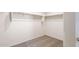 Walk-in closet featuring neutral carpet, white walls, shelving and a hanging rod for optimal organization at 42915 W Palo Amarillo Rd, Maricopa, AZ 85138