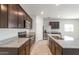 Modern kitchen featuring stainless steel appliances, granite countertops, dark cabinets, and a central island at 42915 W Palo Amarillo Rd, Maricopa, AZ 85138
