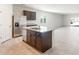 Modern kitchen island with granite countertops, dark cabinets, stainless steel appliances, and neutral tiled floors at 42915 W Palo Amarillo Rd, Maricopa, AZ 85138