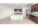Bright, open kitchen with stainless steel appliances, granite countertops, dark cabinets, and a large central island at 42915 W Palo Amarillo Rd, Maricopa, AZ 85138