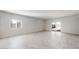 A bright living area featuring neutral tile floors, large windows, and a sliding glass door to outdoor area at 42915 W Palo Amarillo Rd, Maricopa, AZ 85138