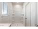 Bright bathroom featuring a shower with built-in shelving, a window, and tile flooring at 42915 W Palo Amarillo Rd, Maricopa, AZ 85138