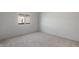 Bright bedroom featuring neutral carpet, white walls, and a sunlit window at 42945 W Palo Amarillo Rd, Maricopa, AZ 85138