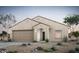 Inviting single-story home featuring a two-car garage and desert landscaping in a neutral color palette at 42945 W Palo Amarillo Rd, Maricopa, AZ 85138