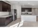 Modern kitchen with stainless steel appliances, granite countertops, a central island, and dark cabinetry at 42945 W Palo Amarillo Rd, Maricopa, AZ 85138