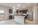 Spacious kitchen featuring a center island, stainless steel appliances, and dark cabinets at 42950 W Palo Amarillo Rd, Maricopa, AZ 85138