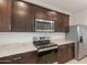 Close up of the new kitchen appliances, dark cabinetry, and granite countertops at 42955 W Palo Amarillo Rd, Maricopa, AZ 85138